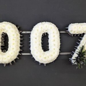 White floral funeral tribute in the shape of the number 007