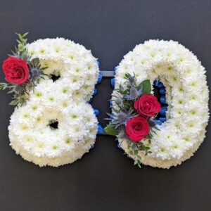Funeral numbers 80 with white flowers and red roses