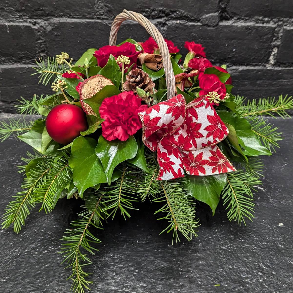 Christmas Flower Basket 1 2 Christmas flower basket with red blooms and greenery – arrangement detail