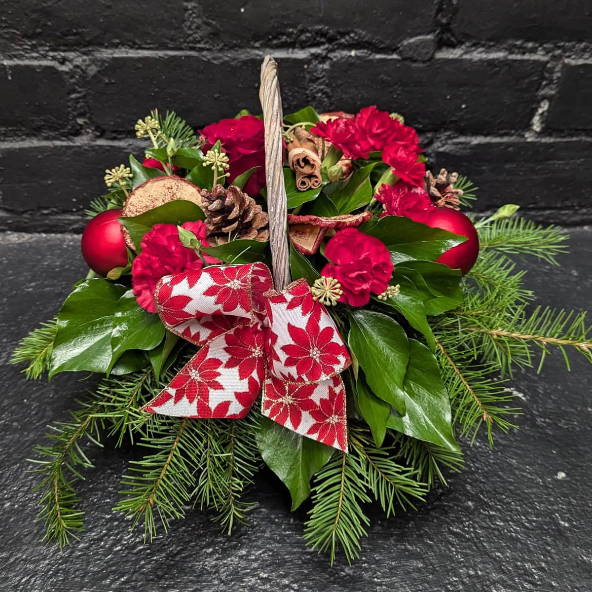 Christmas Flower Basket 1 3 Christmas flower basket with red blooms and greenery – close-up