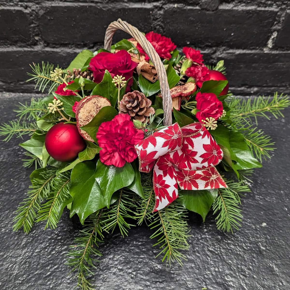 Christmas Flower Basket 1 4 Christmas flower basket with red blooms and greenery