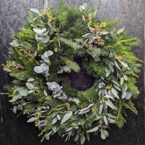 Handcrafted Christmas spruce wreath with seasonal foliage