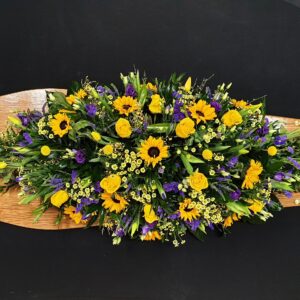 Vibrant yellow and purple funeral coffin spray