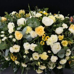 White and yellow funeral coffin spray arrangement