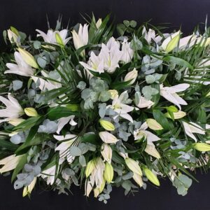 White lily and foliage funeral coffin spray