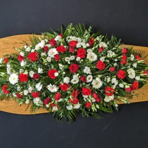 Red and white funeral coffin spray of roses and blooms