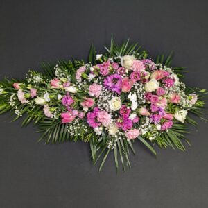 Funeral spray with pink and white flowers and greenery