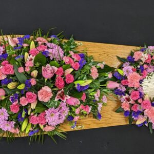Beautiful pink and purple coffin spray with roses, lilies, and chrysanthemums