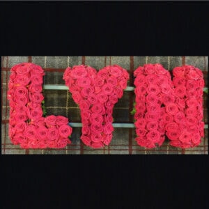 Funeral letters arrangement with red roses forming the name 'LYN'
