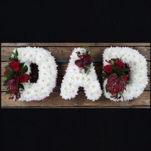 Floral funeral tribute spelling DAD with white flowers