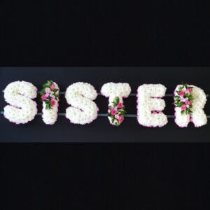 Funeral tribute with flowers spelling 'SISTER'