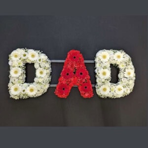 Floral funeral letter tribute spelling 'DAD' in white and red flowers