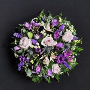 Purple and cream funeral posy with roses and thistles
