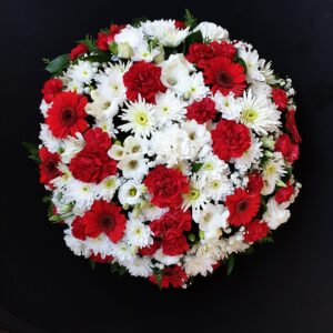 Red and white funeral posy with carnations and daisies.