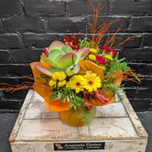 Seasonal Pumpkin Delight flower arrangement featuring yellow gerberas, chrysanthemums, and red carnations inside a real pumpkin container.