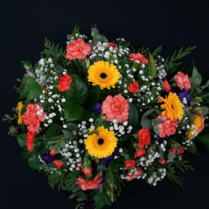 Funeral spray with vibrant flowers and greenery