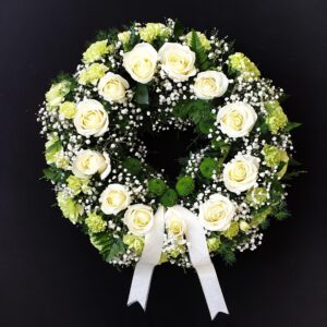 White rose and greenery funeral wreath tribute