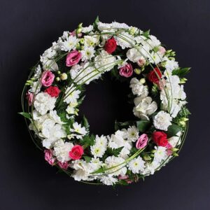 White and pink funeral flower wreath with roses and carnations