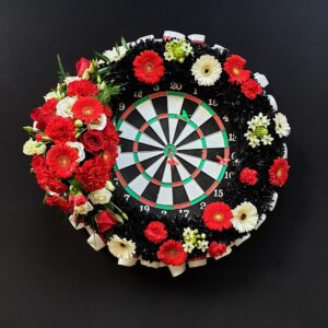 Dartboard decorated with vibrant funeral flowers
