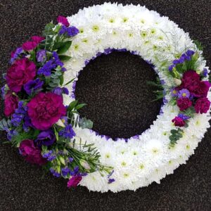 White and purple funeral flower wreath tribute