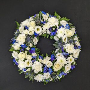 White and blue funeral flower wreath with roses and chrysanthemums